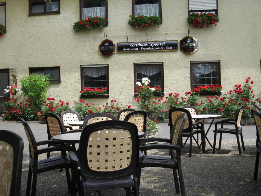 eine Gruppe von Tischen und Stühlen vor einem Gebäude in der Unterkunft Gasthaus Sponsel in Oberfellendorf
