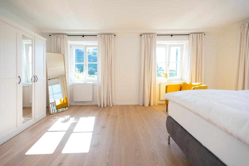 a bedroom with a large bed and some windows at Huberhof Meran in Merano