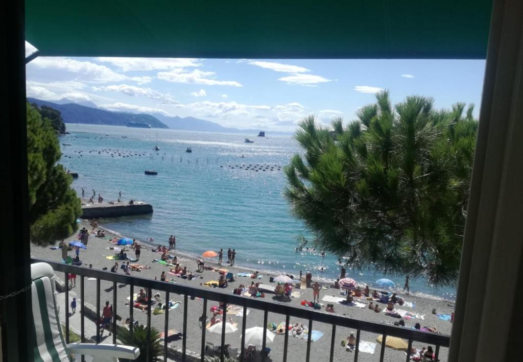 - une vue sur la plage avec des gens dans l'eau dans l'établissement Olivo apartment with sea view, à Portovenere