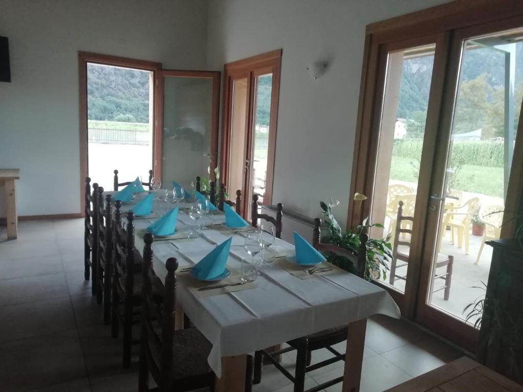 a dining room with a long table with blue napkins at Agriturismo Summus Lacus in Riva