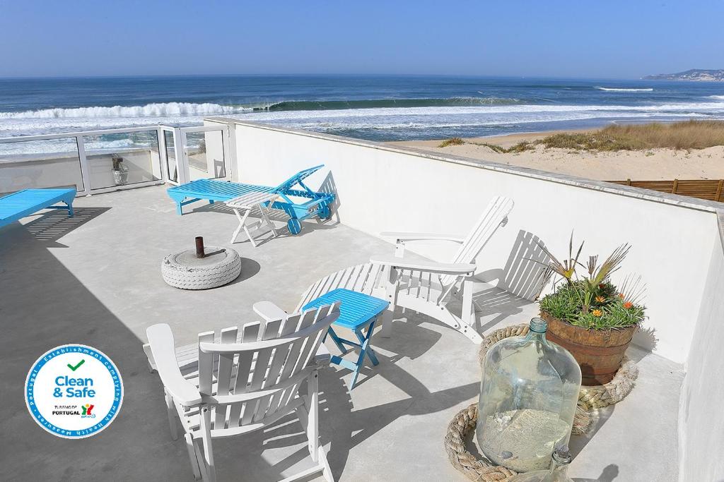 a patio with chairs and a table with the beach at Casa na Areia in Lavos