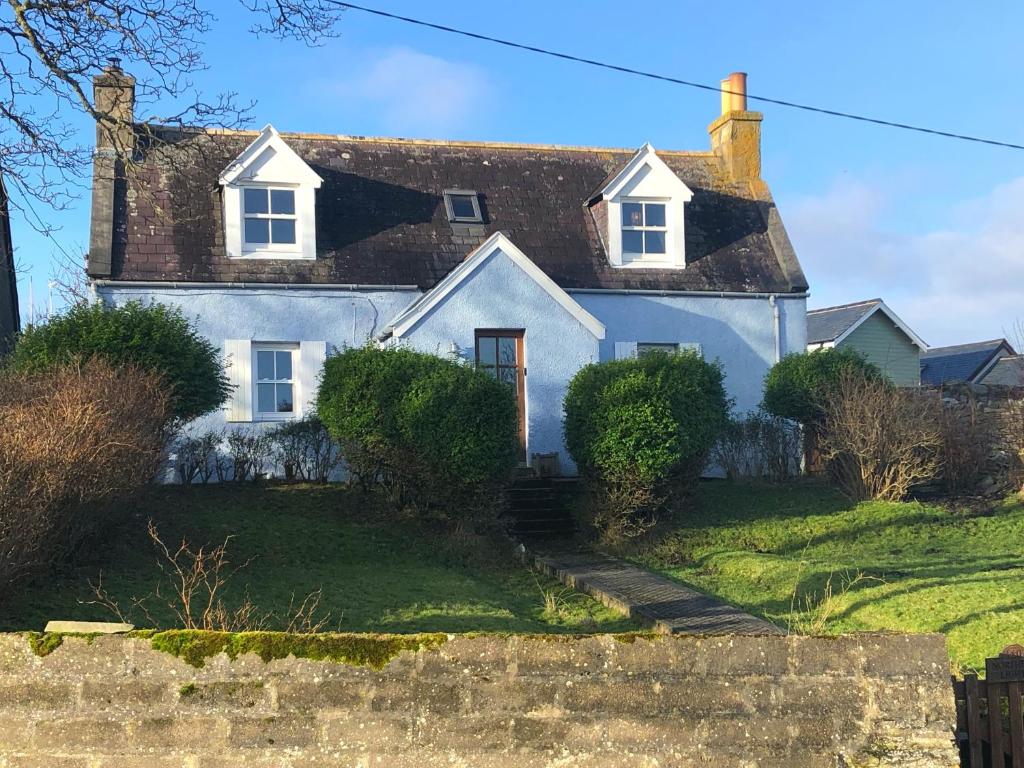 a white house with a thatched roof at Northern Lights in Talmine