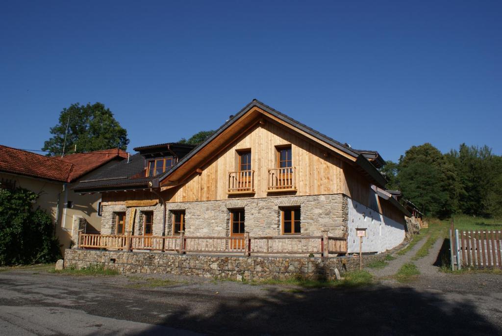 Cette grande maison en bois possède un balcon. dans l'établissement Charmante Ferienwohnung im Landhausstil, à Kašperské Hory