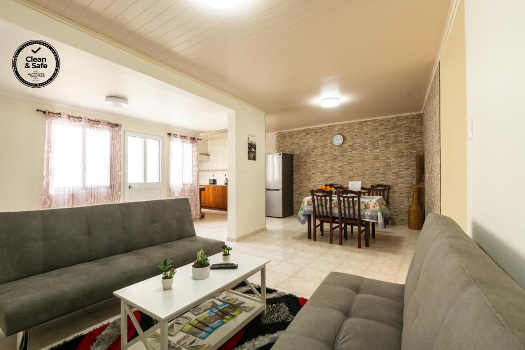 a living room with a couch and a table at Casa Piscinas Naturais in Ribeira Grande