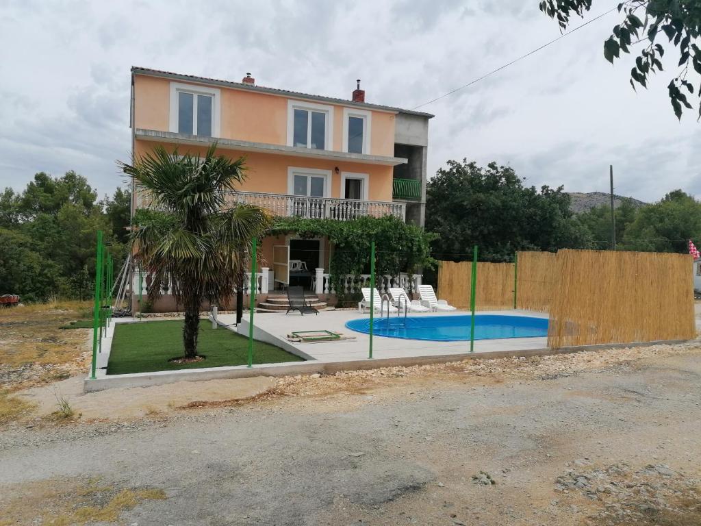 a villa with a swimming pool in front of a house at apartman Bruna in Šibenik