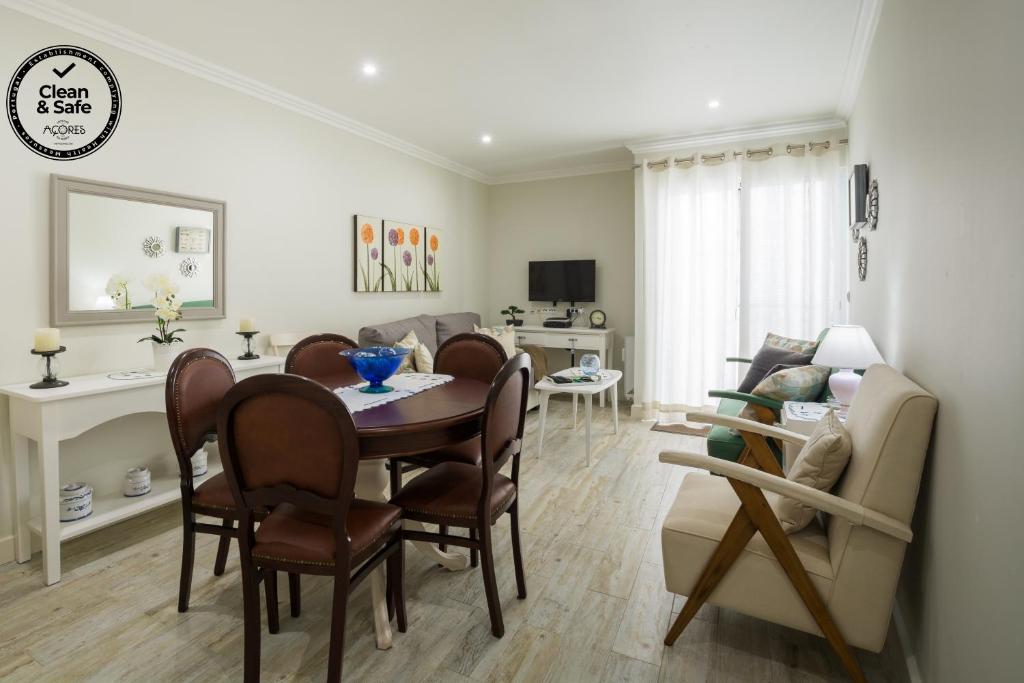 uma sala de jantar e sala de estar com mesa e cadeiras em Canadian Villa em Ponta Delgada