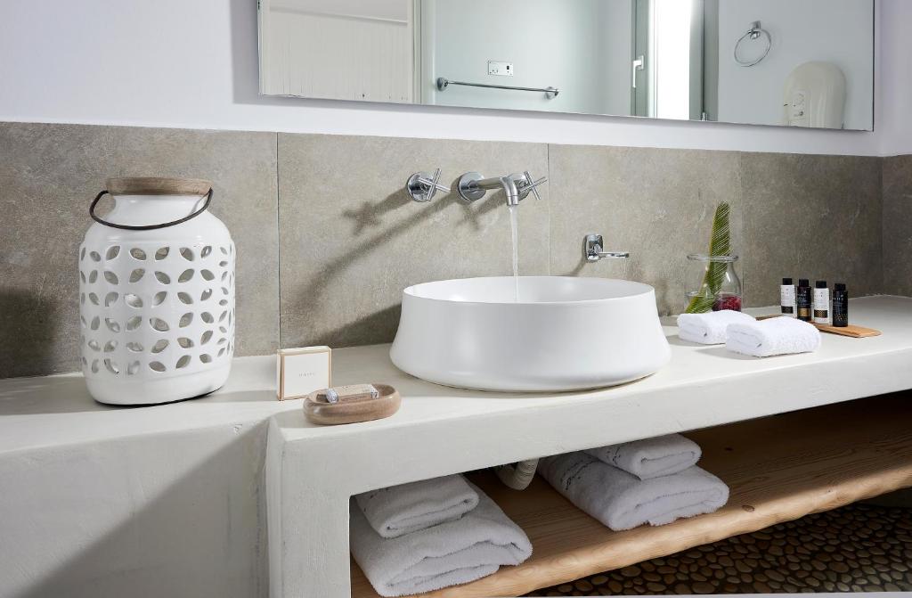 a bathroom with a sink and a counter with towels at Santa Maria Luxury Suites & Spa in Adamas