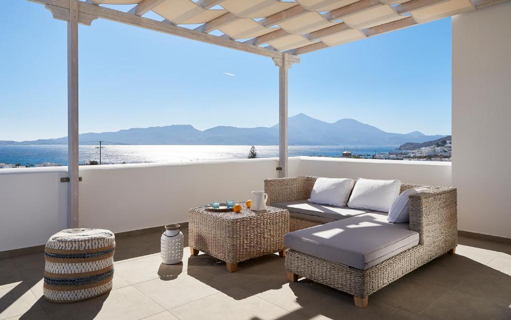 a patio with a couch and chairs and a table at Santa Maria Luxury Suites & Spa in Adamantas
