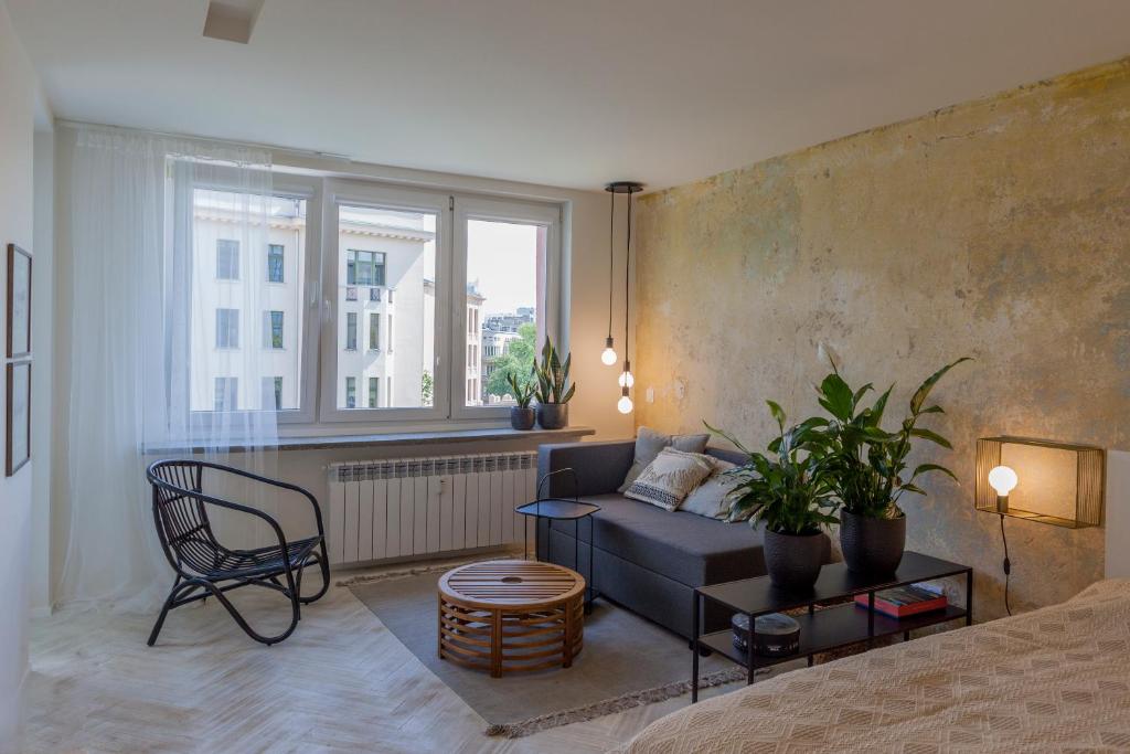 uma sala de estar com um sofá e uma janela em Uni Apartament em Lódź
