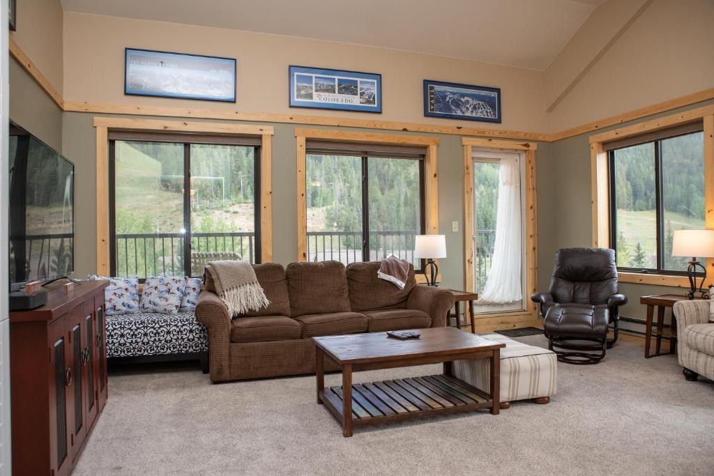 een woonkamer met een bank en een tafel bij 2800 Slopeside condo in Keystone