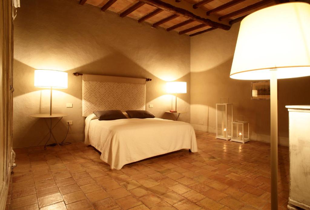 1 dormitorio con 1 cama blanca y 2 lámparas en Colle al Matrichese - Historic Winery, en Montalcino