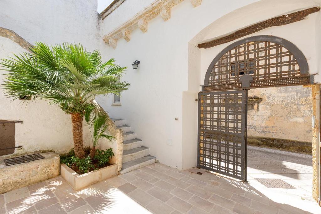 an entrance to a building with a gate and a palm tree at Antica dimora stasi by BarbarHouse in Presicce