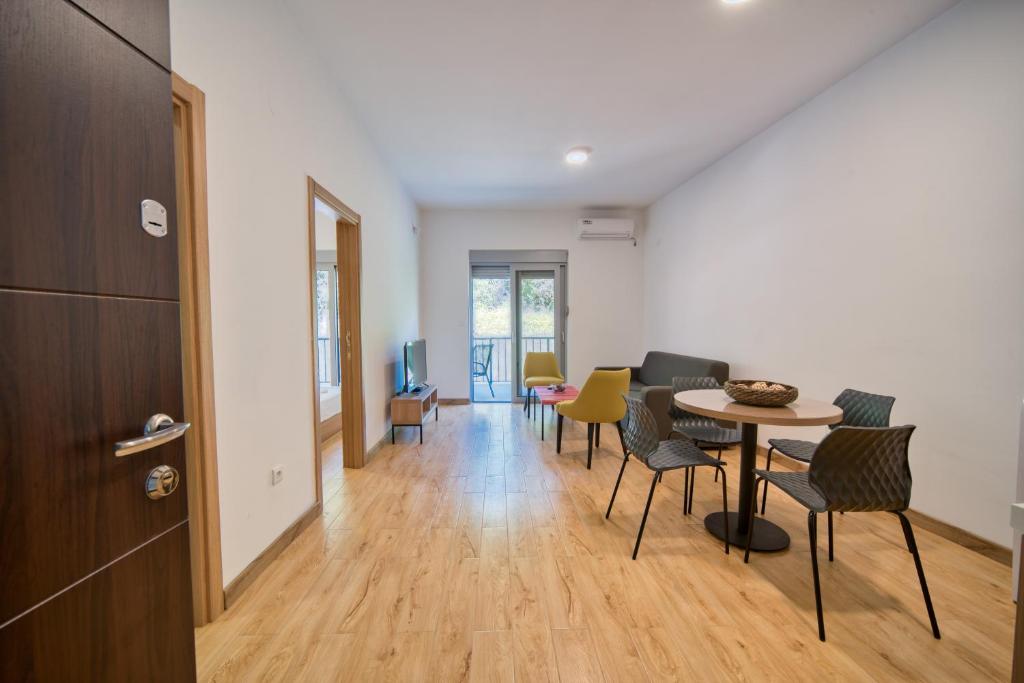 a room with a table and chairs and a hallway at Trsteno Beach Apartments in Budva