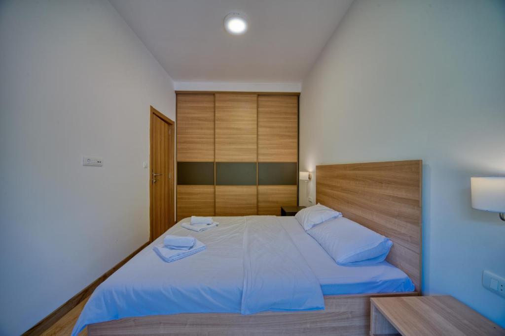 a bedroom with a large bed with blue sheets at Trsteno Beach Apartments in Budva