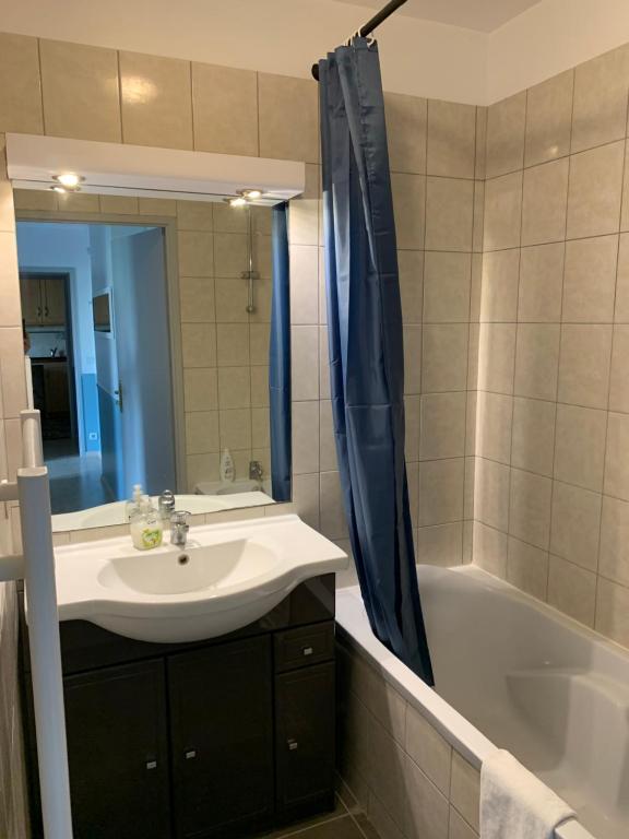 a bathroom with a sink and a shower curtain at Disney, comfortable 2 bedrooms family apartment, 7 pers, wifi, NETFLIX in Chessy