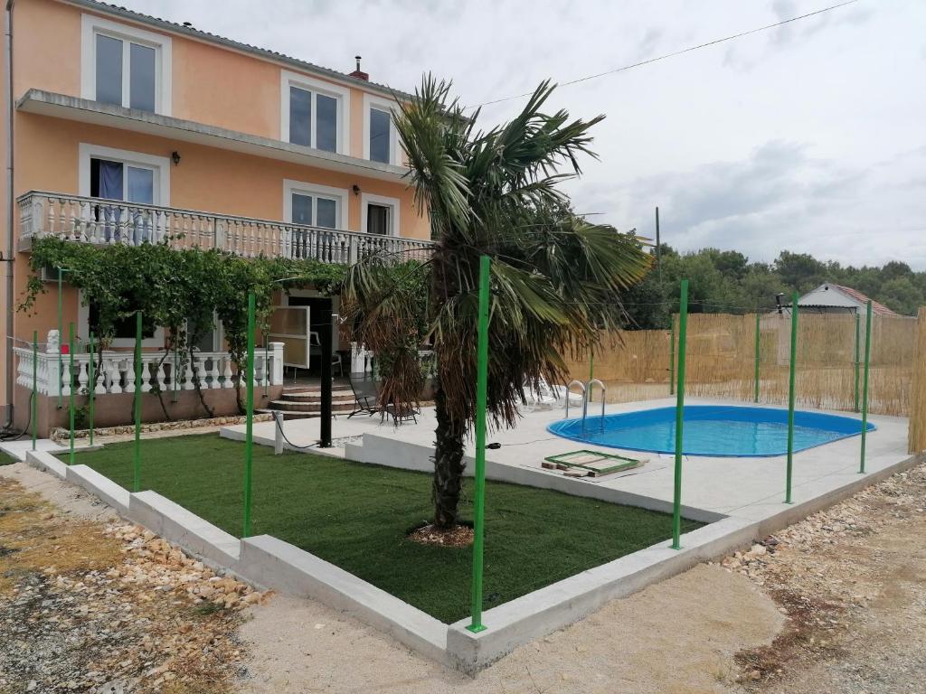 dom z palmą i basenem w obiekcie apartmani Bruna Bilice w mieście Vrulje