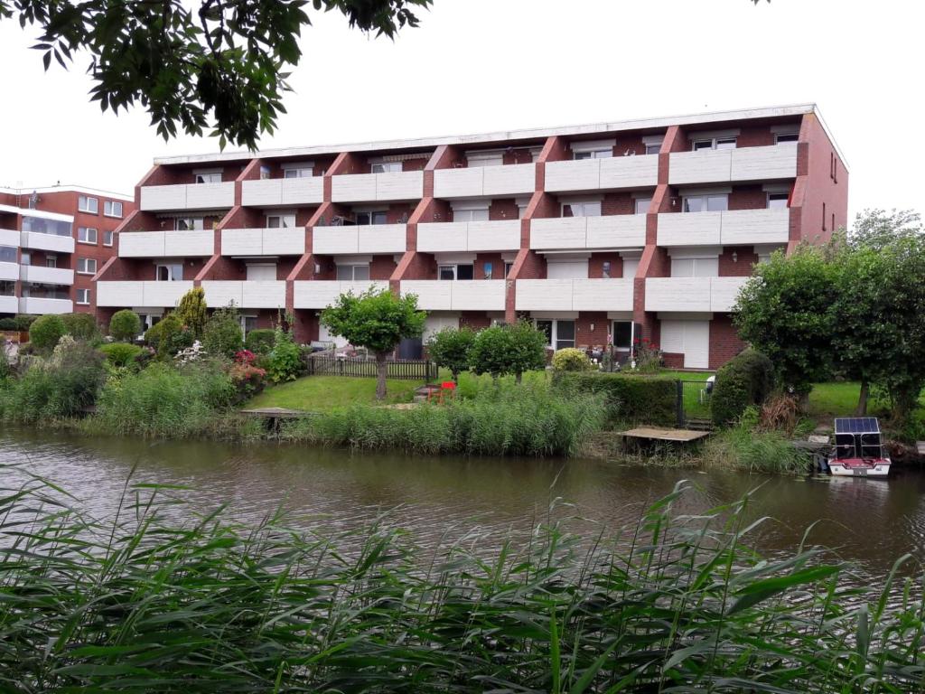 ein Apartmenthaus neben einem Wasserkörper in der Unterkunft Ferienwohnung "Sielblick" in Dornumersiel in Dornum