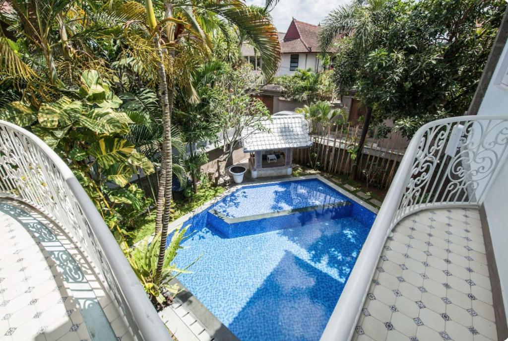 an image of a swimming pool on a balcony with two chairs at Villa Alexandra Seminyak in Kerobokan