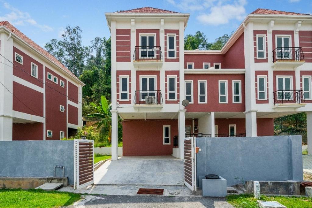 a large red and white building with a driveway at Suraya Homestay Semi-D in Sepang