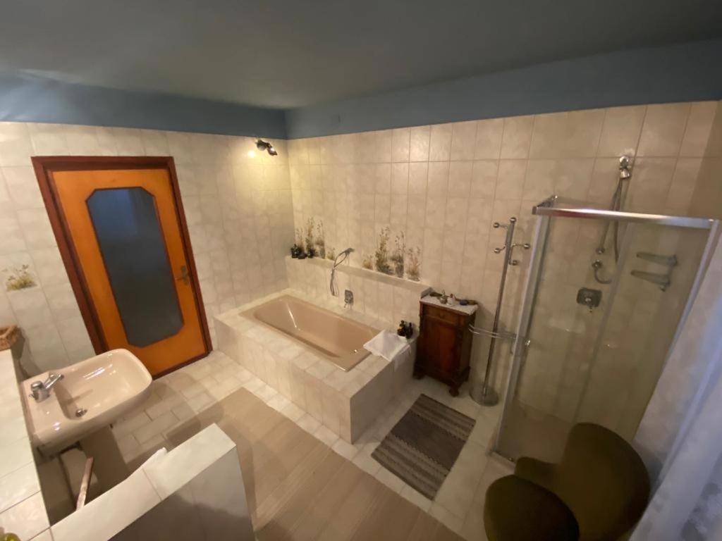 ein Badezimmer mit einem Waschbecken, einer Badewanne und einer Dusche in der Unterkunft MAMOTA B&B in Vesime
