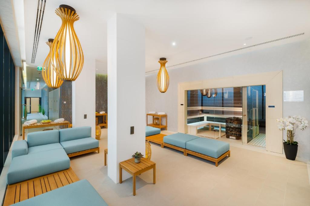 a living room with blue couches and a dining room at Hotel Vision Budapest by Continental Group in Budapest