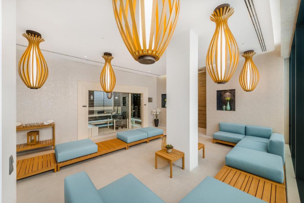 a living room with blue couches and orange chandeliers at Hotel Vision Budapest by Continental Group in Budapest
