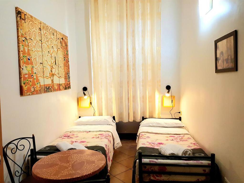 a bedroom with two beds and two lamps at Legend R.G. in Rome