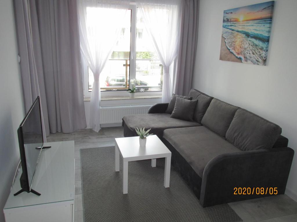 a living room with a couch and a table at Apartament Oskar in Kołobrzeg