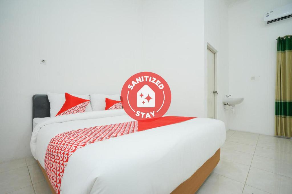 a bedroom with a bed with a sign on it at Super OYO 2489 Choco 88 Residence in Probolinggo