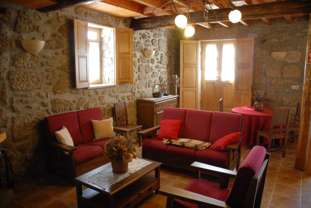 a living room with two red couches and a table at Casa da Moreia in Sabugueiro