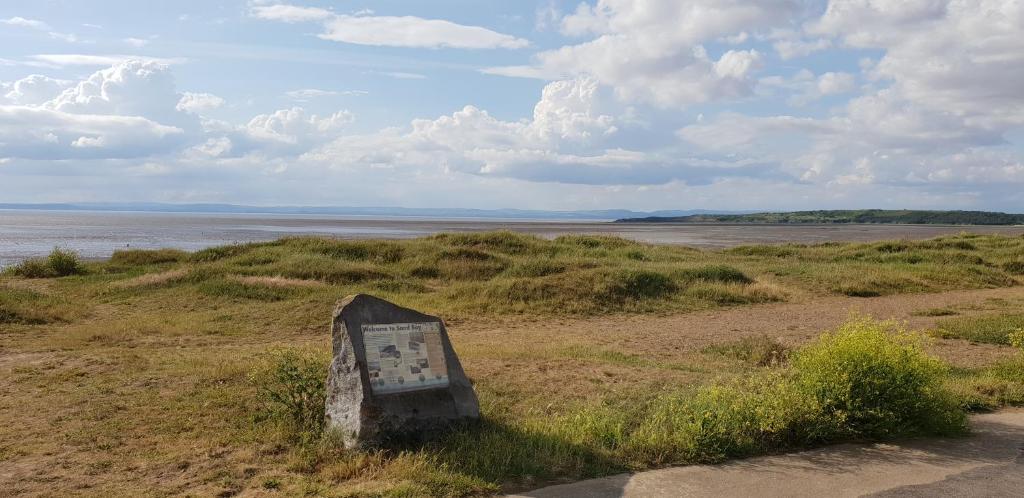 a sign in the grass near a body of water at South Sands Hotel in Weston-super-Mare