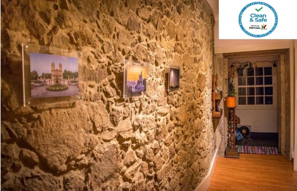 uma parede de pedra com imagens num quarto em inBraga Hostel em Braga