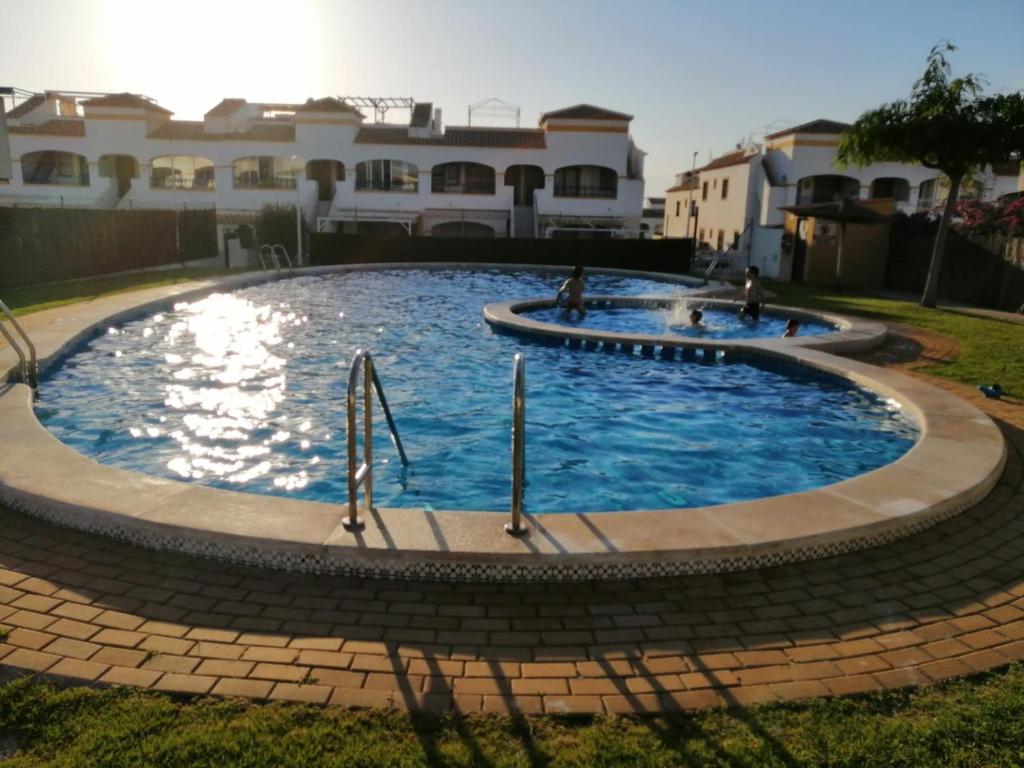 uma grande piscina num quintal com casas em Apartamento adosado cerca del mar em Gran Alacant