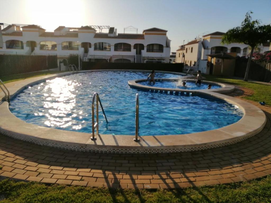 una gran piscina en un patio con casas en Apartamento adosado cerca del mar, en Gran Alacant