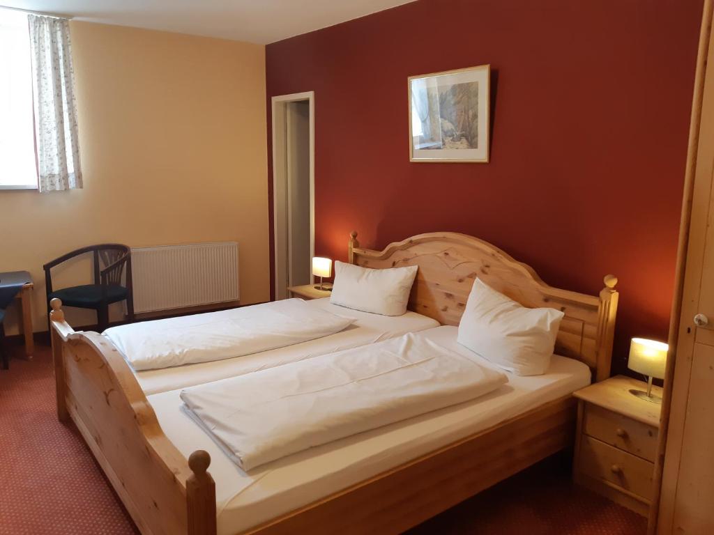 1 dormitorio con 2 camas con sábanas blancas en Werdenfelser Hof, en Garmisch-Partenkirchen