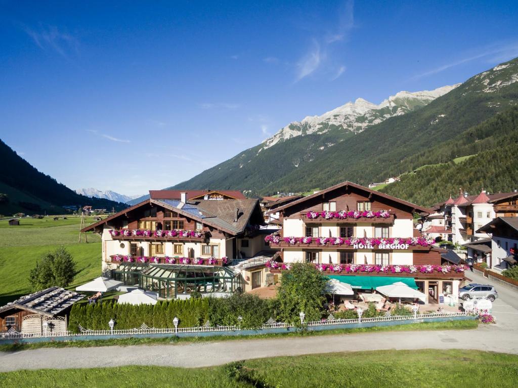 a hotel in the mountains with mountains in the background at Hotel Berghof in Neustift im Stubaital