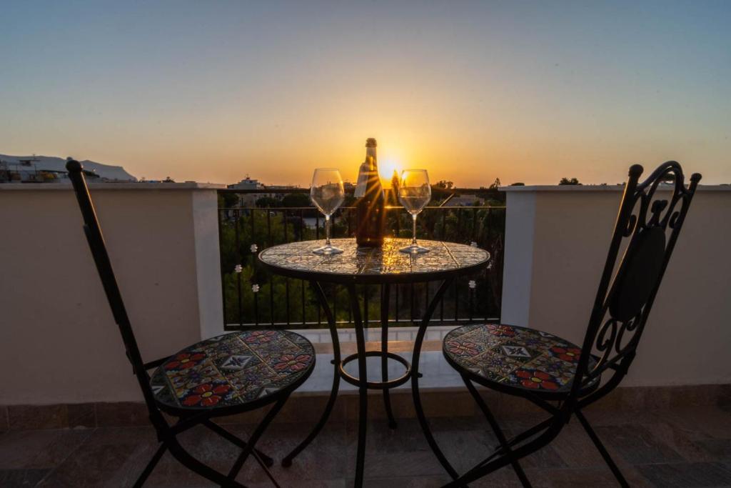 uma mesa e 2 cadeiras com copos de vinho na varanda em La Casetta sul Mare em Isola delle Femmine