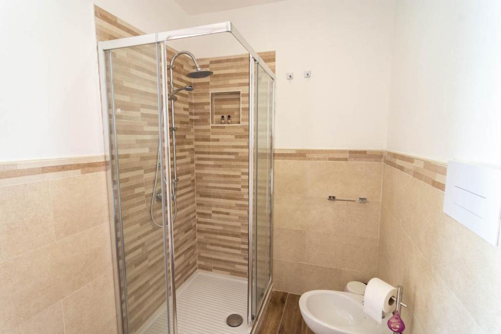 a bathroom with a shower and a toilet and a sink at La Casetta sul Mare in Isola delle Femmine