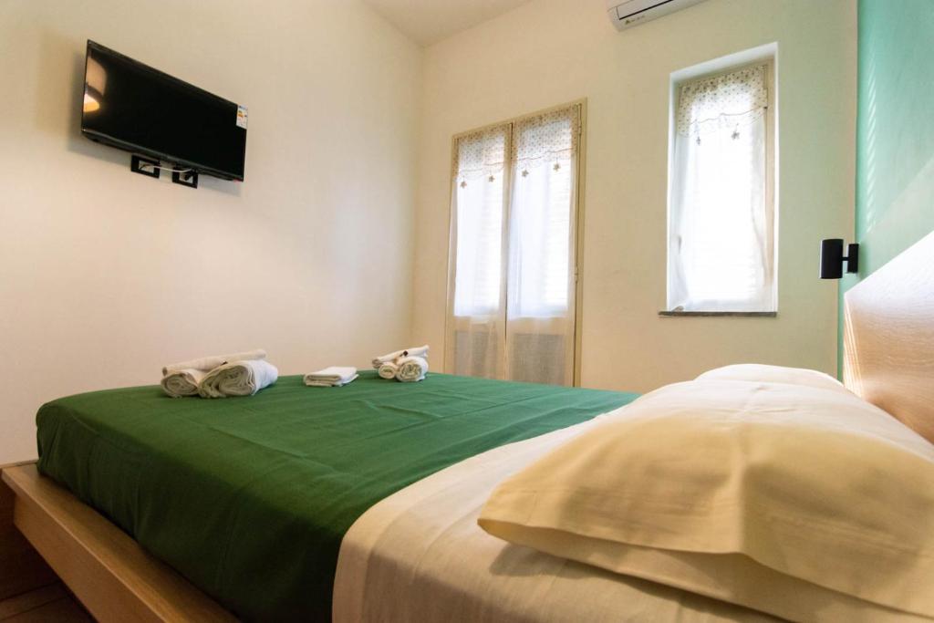 a bedroom with a green bed with towels on it at La Casetta sul Mare in Isola delle Femmine