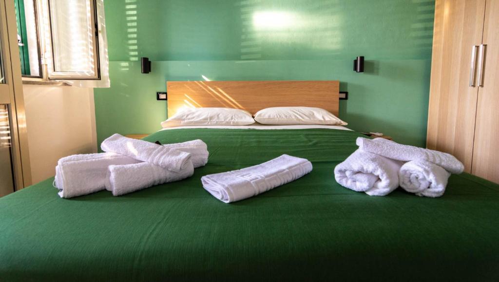a large green bed with towels on top of it at La Casetta sul Mare in Isola delle Femmine