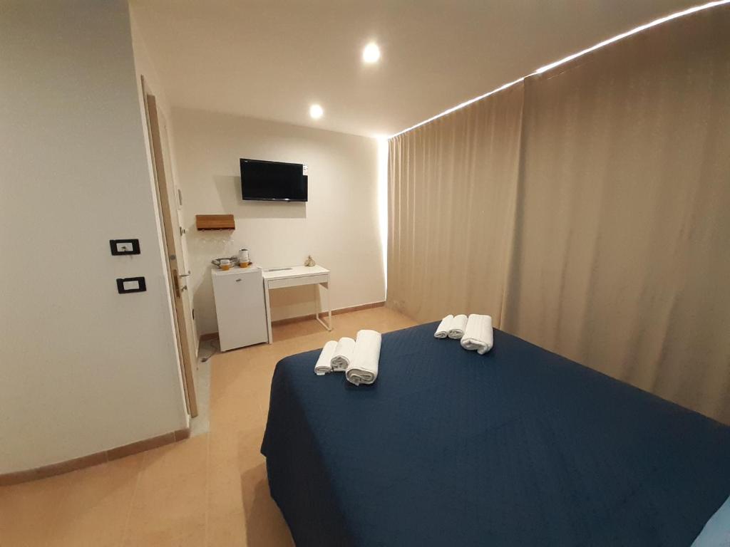 a bedroom with a blue bed with towels on it at La Casetta sul Mare in Isola delle Femmine