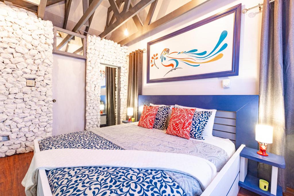 1 dormitorio con 1 cama y una pintura en la pared en Parrot Cottage at Viking Hill - Love Beach, en Nassau