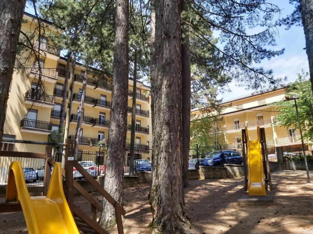 einen Spielplatz vor einem Gebäude mit Bäumen in der Unterkunft Hotel Meranda in Camigliatello Silano