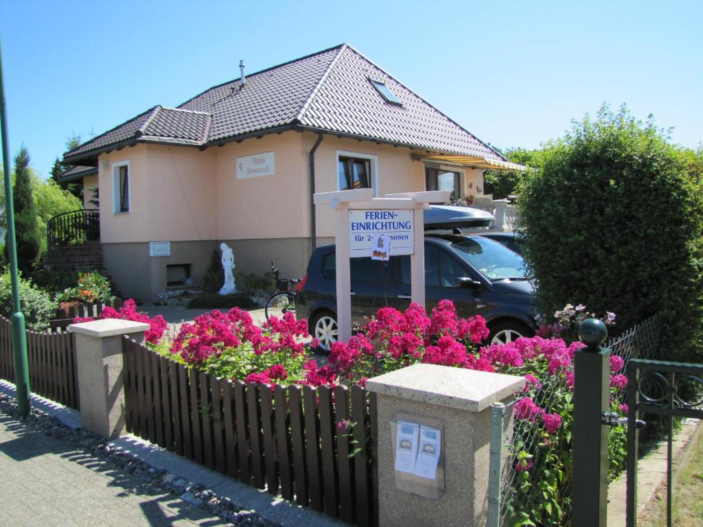 a sign in front of a house with pink flowers at Haus Roseneck Seebad Ückeritz auf Insel Usedom Vermietung im Bereich Souterrain ! in Ueckeritz