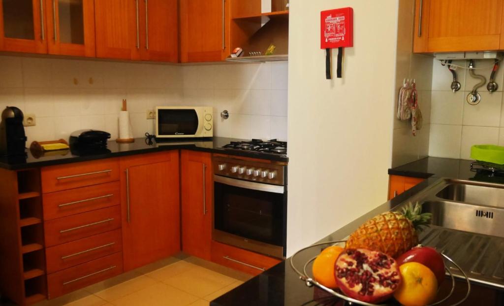 a kitchen with a bowl of fruit on a counter at Duplex Oceanos in Ponta Delgada