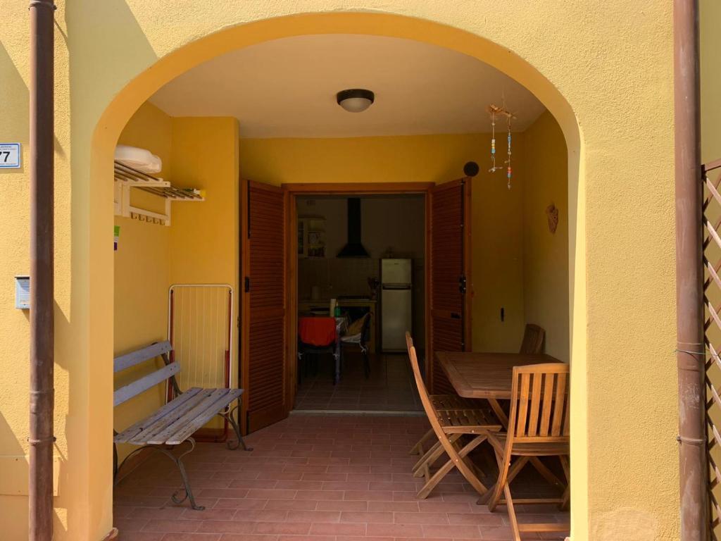 einen Torbogen, der in ein Esszimmer mit einem Tisch und Stühlen führt. in der Unterkunft Casa Peonia in Alberese