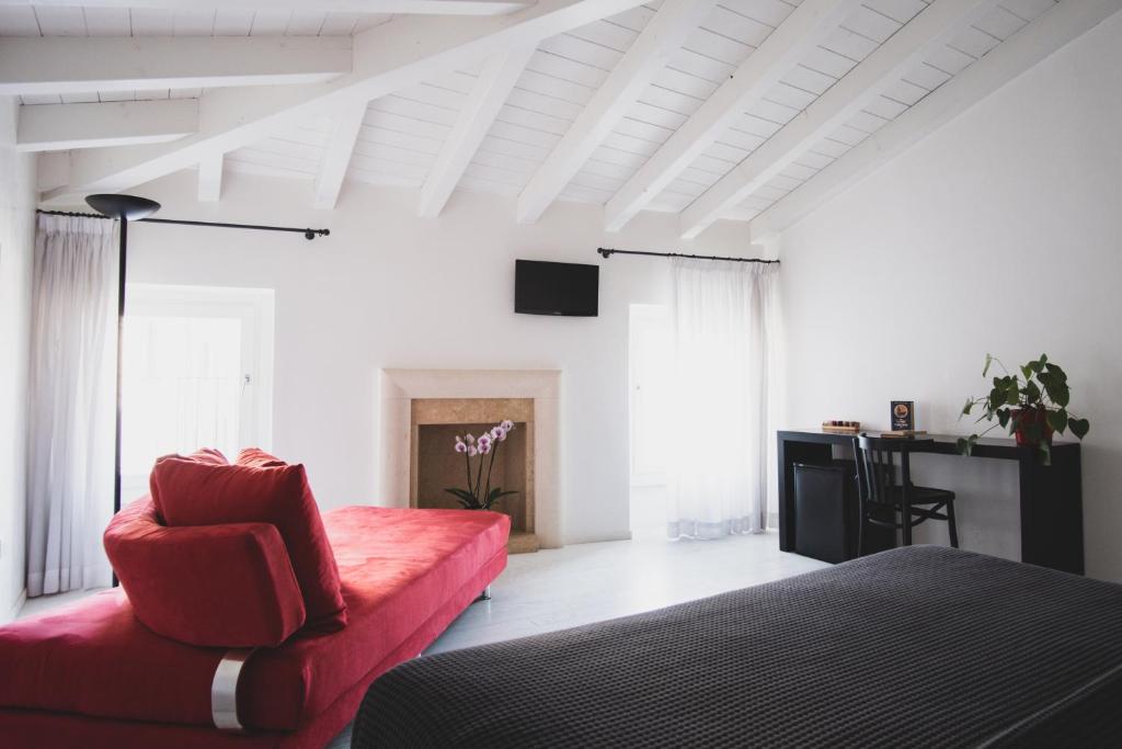 sala de estar con sofá rojo y TV en Casa Fola - City Centre Rooms, en Verona