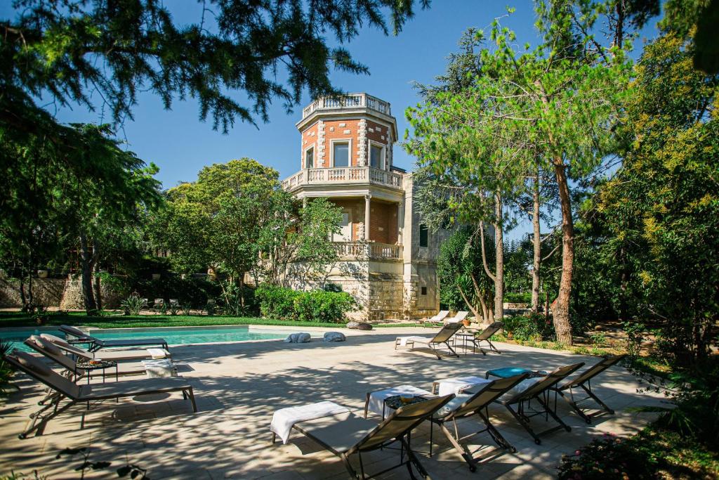 a house with a pool and chairs in front of it at Villa Rosa Resort in Conversano