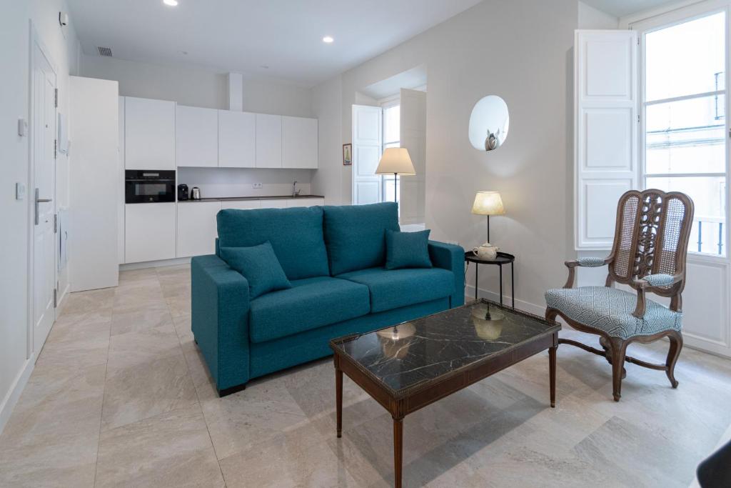 sala de estar con sofá azul y mesa en Apartamento Cadiz Wonderland, en Cádiz