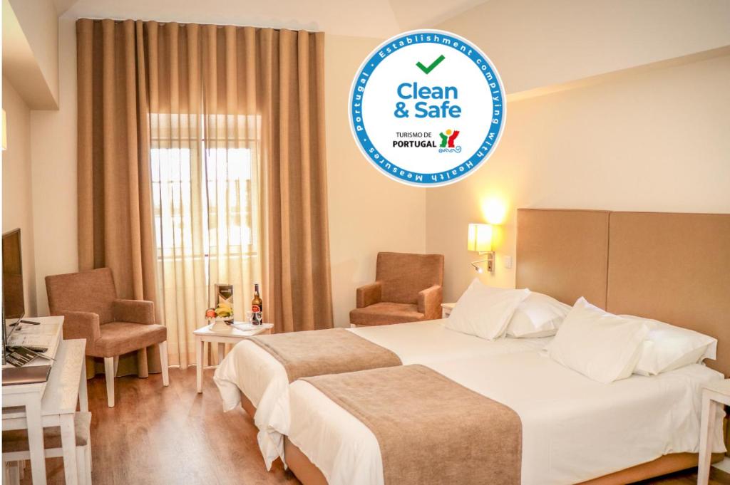 a hotel room with two beds and a sign that says clean and safe at Hotel Solar Bom Jesus in Santa Cruz